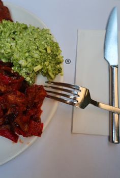 Close-up of a vibrant vegetarian dish featuring broccoli and a red vegetable medley.