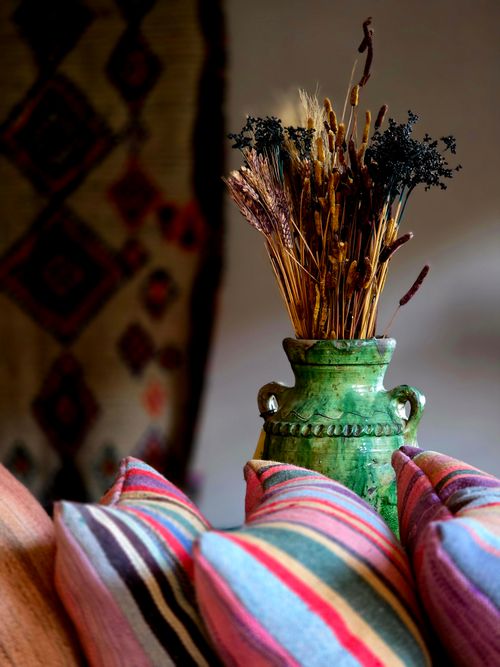 Free Colorful Moroccan textiles and green vase create a vibrant, artistic setting. Stock Photo