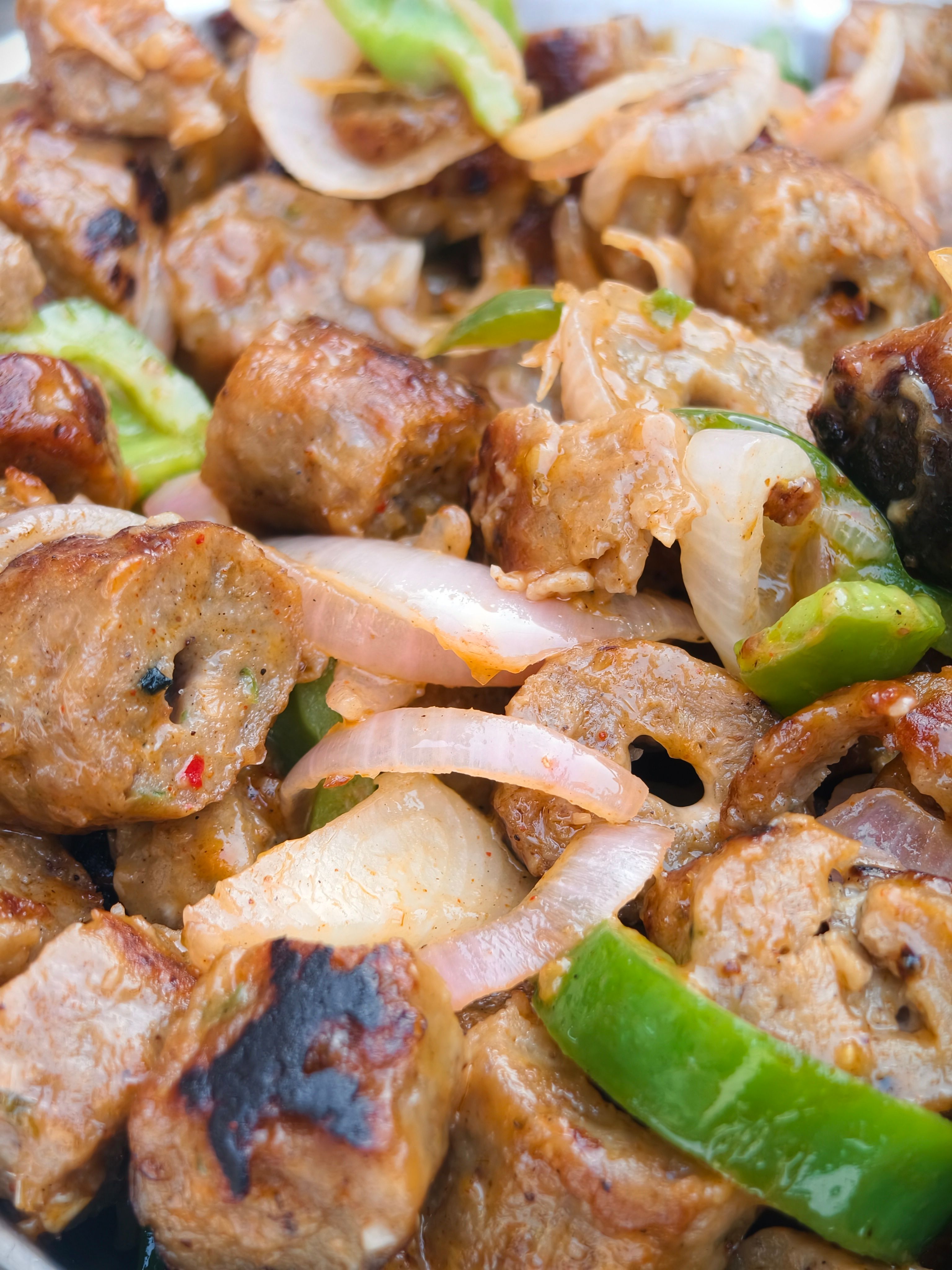 Delicious grilled sausages with onions and peppers, perfect for a summer BBQ.