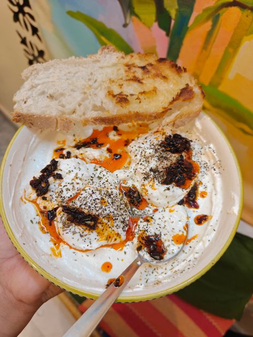 Free A tantalizing dish of Turkish poached eggs with spicy yogurt sauce and bread. Stock Photo