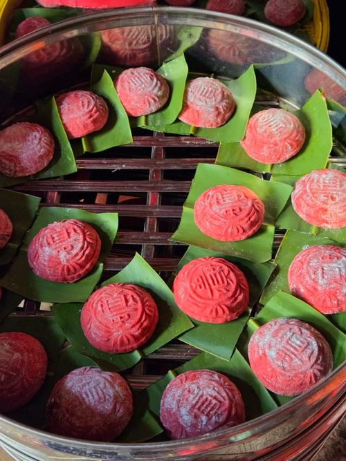 Free Colorful red Ang Ku Kueh on banana leaves in a steamer, ready for serving. Stock Photo