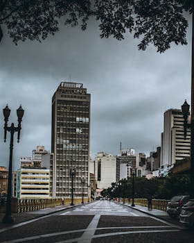 在阴沉的天空下，高耸的摩天大楼与空荡荡的街道构成了阴沉的城市景观