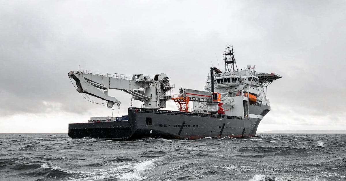 Photo by Jan-Rune Smenes Reite A large industrial ship cruising through a stormy sea under a cloudy sky, showcasing marine engineering and transportation.