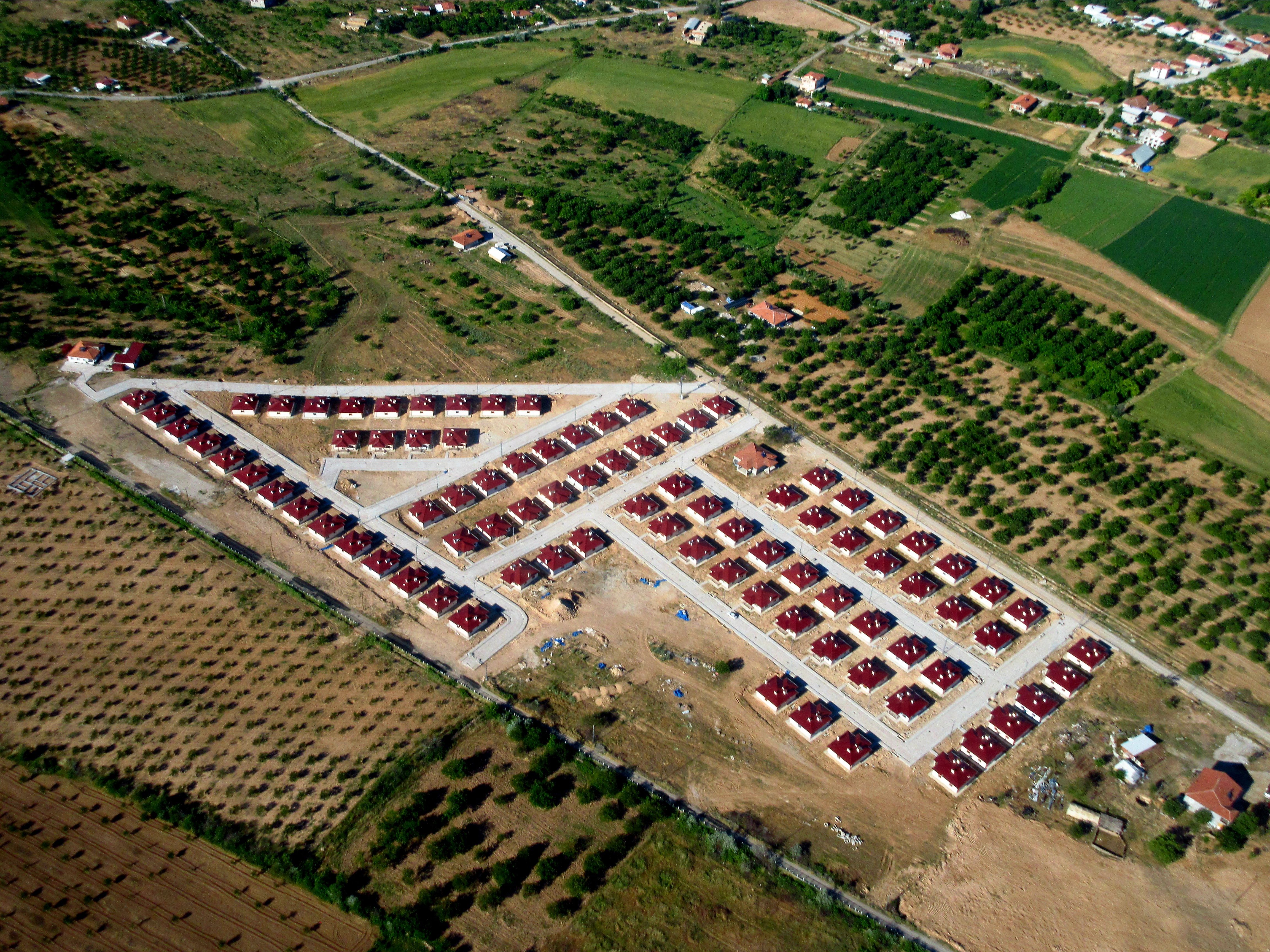 Aerial shot of a housing development amidst fields in Malatya, showcasing rural landscape and urban planning.