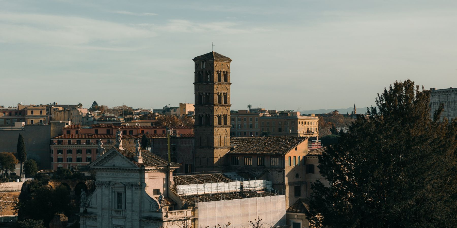 A stunning view of historic Roman architecture bathed in warm sunset light, showcasing iconic structures in Rome, Italy.