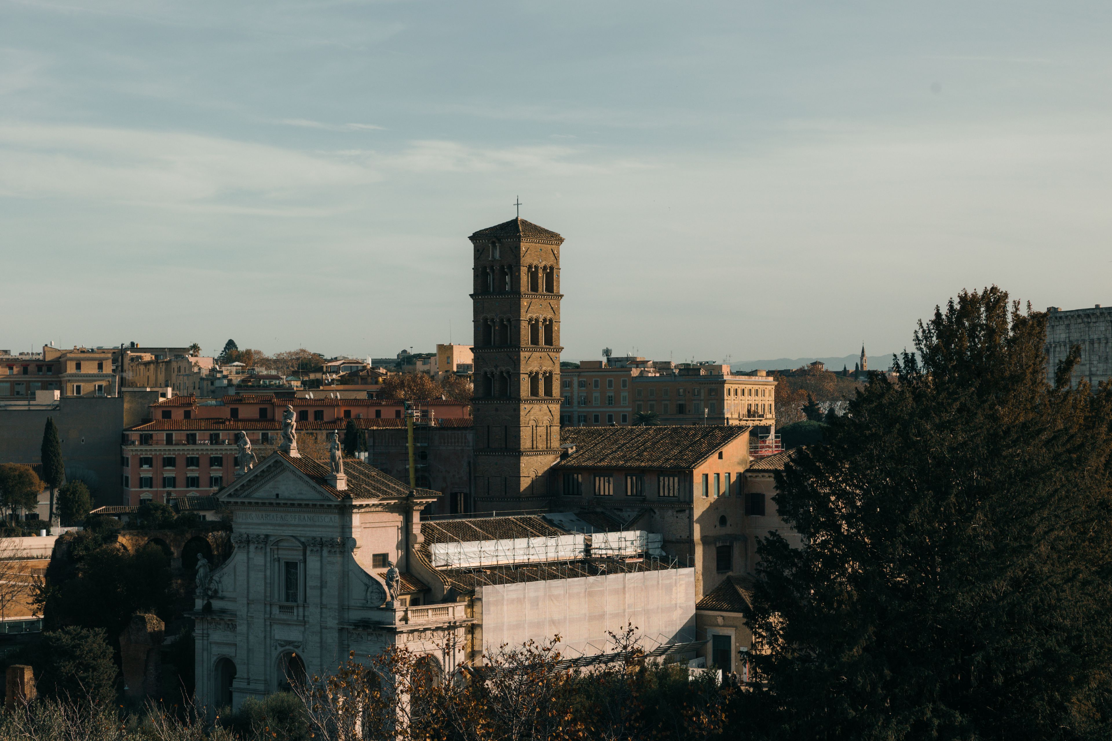 A stunning view of historic Roman architecture bathed in warm sunset light, showcasing iconic structures in Rome, Italy.