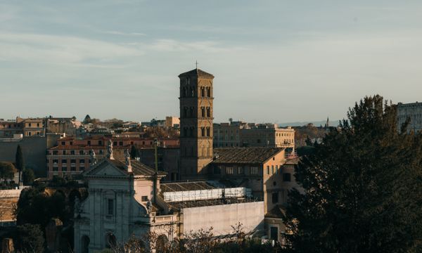 A stunning view of historic Roman architecture bathed in warm sunset light, showcasing iconic structures in Rome, Italy.