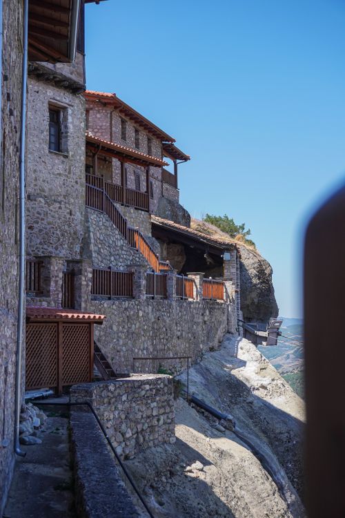 Free Cliffside view of Meteora monastery with stone architecture in Greece under clear blue sky. Stock Photo