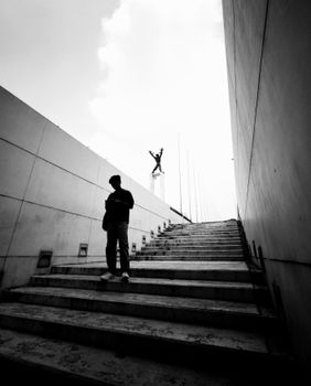 Black and white silhouette of a person on stairs leading to a monument in Jakarta, Indonesia.