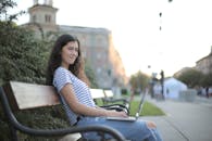 Woman in Black and White Striped Shirt Sitting on Wooden Bench