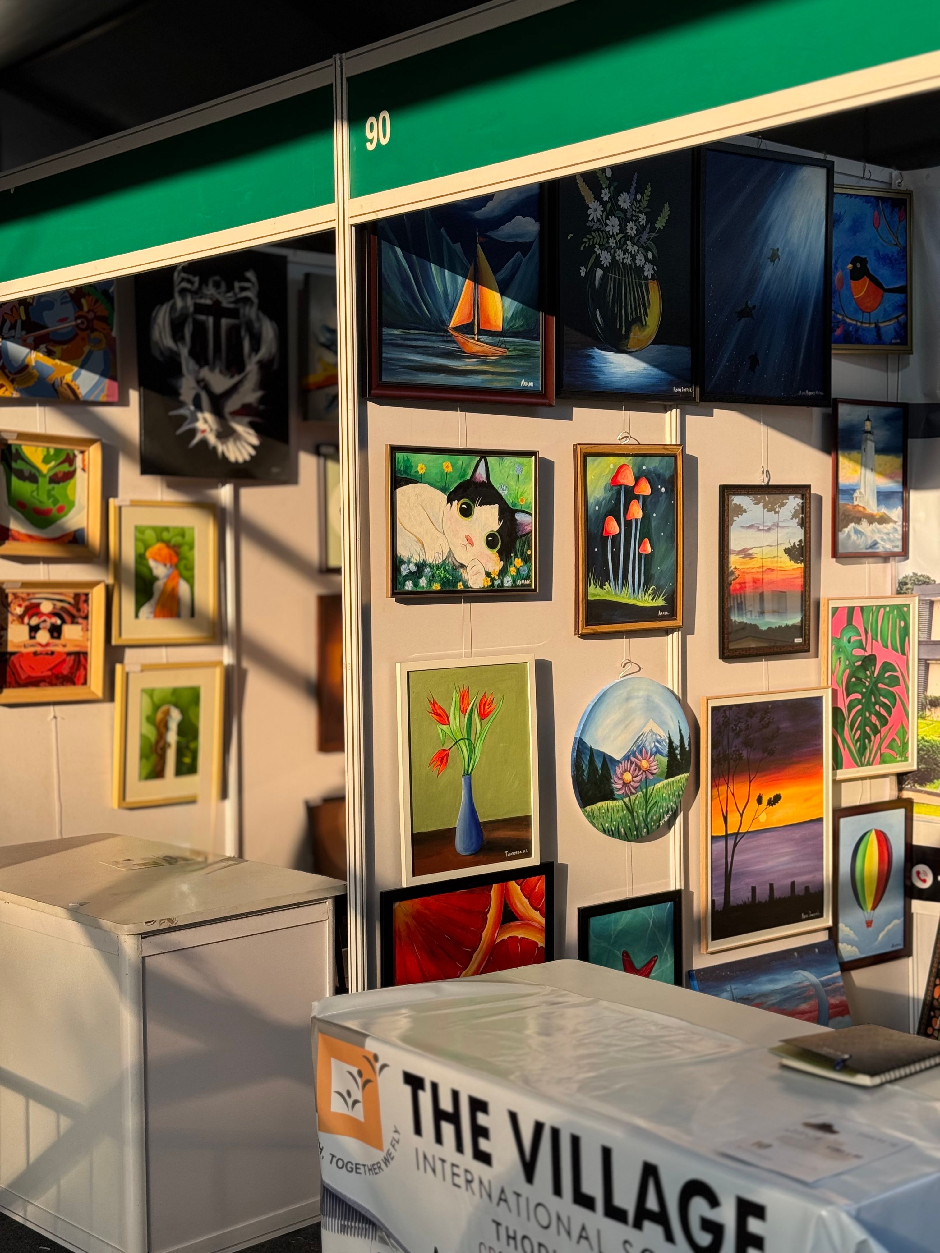 Colorful paintings on display at a local art market stall, showcasing diverse styles and themes.