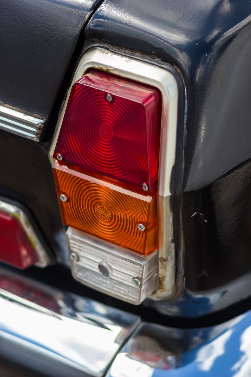 Free Close-up view of a classic car's tail light with red and orange lenses. Stock Photo
