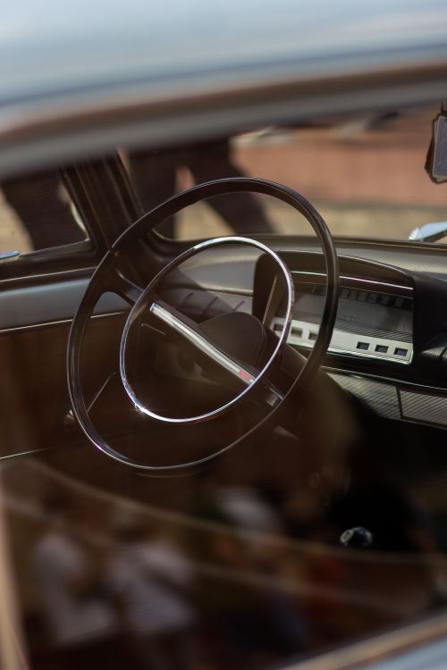 Free Close-up of a vintage car interior showcasing the classic steering wheel design. Stock Photo