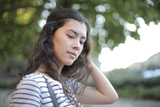 Woman in White and Black Stripe Shirt While Holding Her Hair