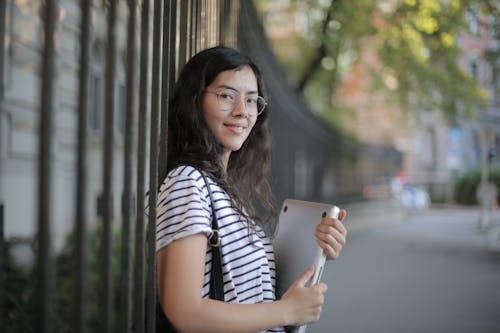 Woman in Black and White Striped Shirt Holding Laptop