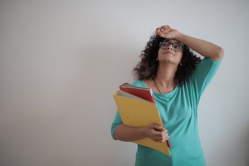 Free Overworked adult female entrepreneur with papers in light modern office Stock Photo