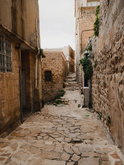 Free Explore the rustic stone-lined alleyways of Mardin, Türkiye, capturing a timeless historical charm. Stock Photo