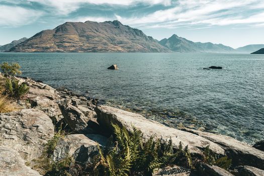 Stunning view of Lake Wakatipu with mountain backdrop in New Zealand, ideal for nature enthusiasts.