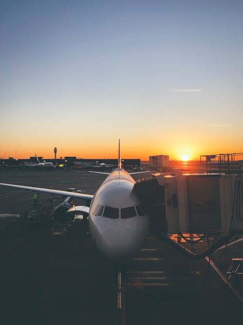 日没時の空港の白い飛行機