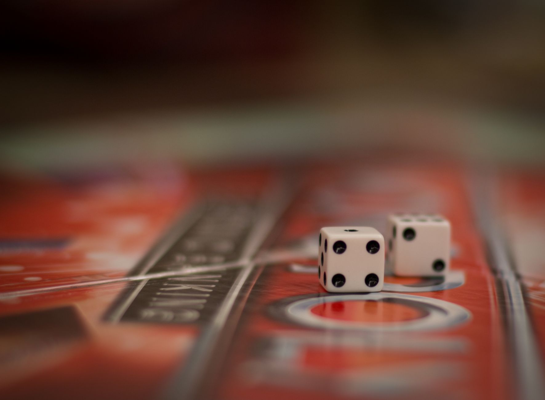 Two dice resting on a colorful board game surface, symbolizing chance and strategy.