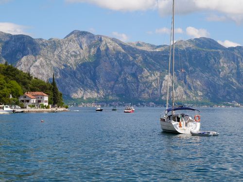 Free Serene view of a sailboat in the scenic Bay of Kotor, Montenegro with mountain backdrop. Stock Photo