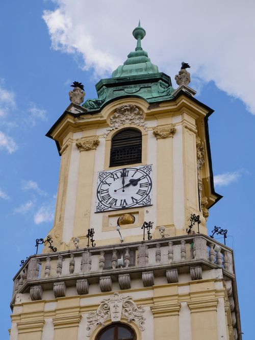 Free Ornate clock tower with a green dome against a blue sky, showcasing classic architecture. Stock Photo