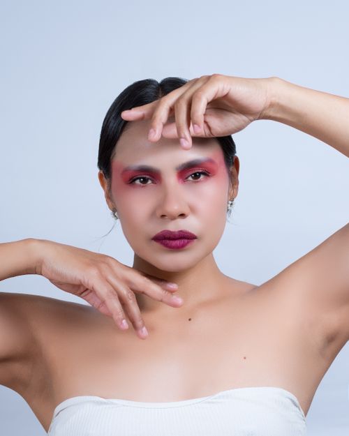 Free Studio portrait of a woman with vibrant makeup and expressive pose, highlighting artistic beauty. Stock Photo