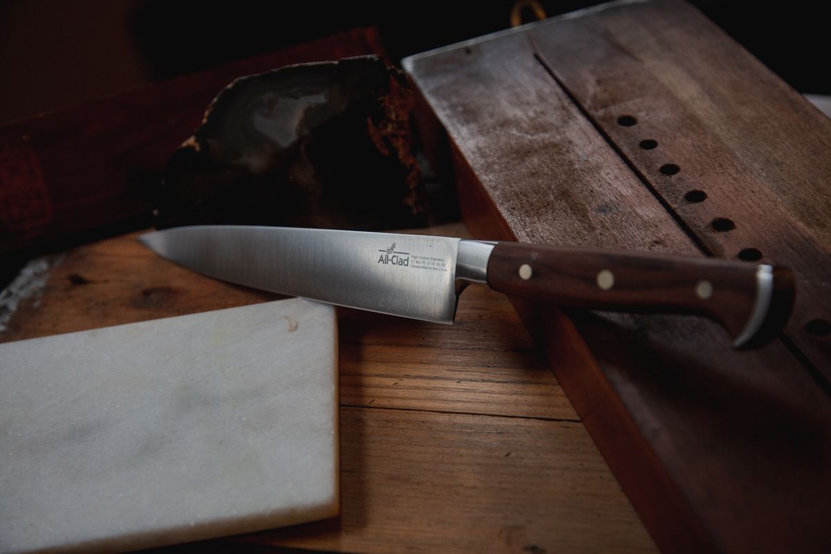 Single-bevel honyaki gyuto chef knife resting on dark slate