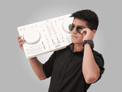 Young DJ posing with a turntable and sunglasses in a studio setting. Captured in Peru.
