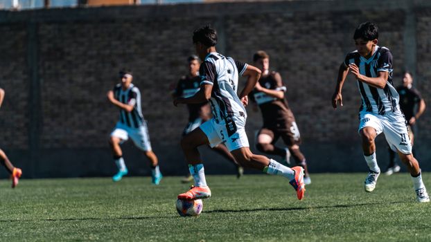 Athletes in action during an outdoor soccer match, daytime.