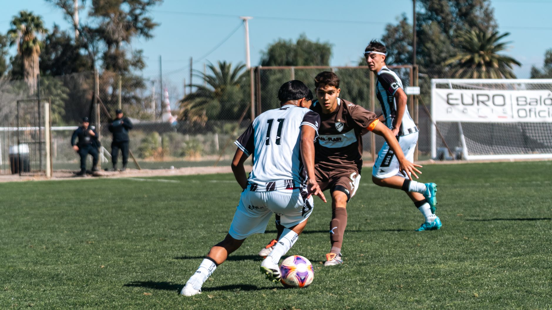 Dynamic outdoor youth soccer match with players in motion, showcasing teamwork and competitive spirit.
