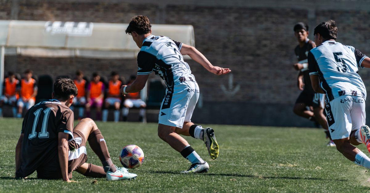 exhausted soccer player sitting on pitch after match