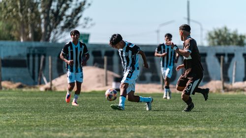 Free Four young soccer players compete fiercely on a sunny day, showcasing athletic skill and teamwork. Stock Photo