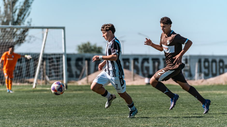 Dynamic action shot of two soccer players competing on the field during a match.