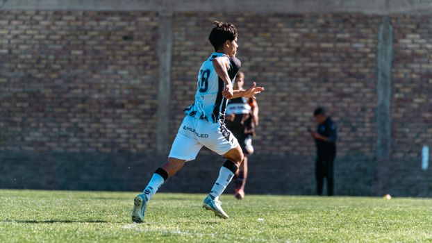 Dynamic shot of a young soccer player in mid-action during a game outdoors.