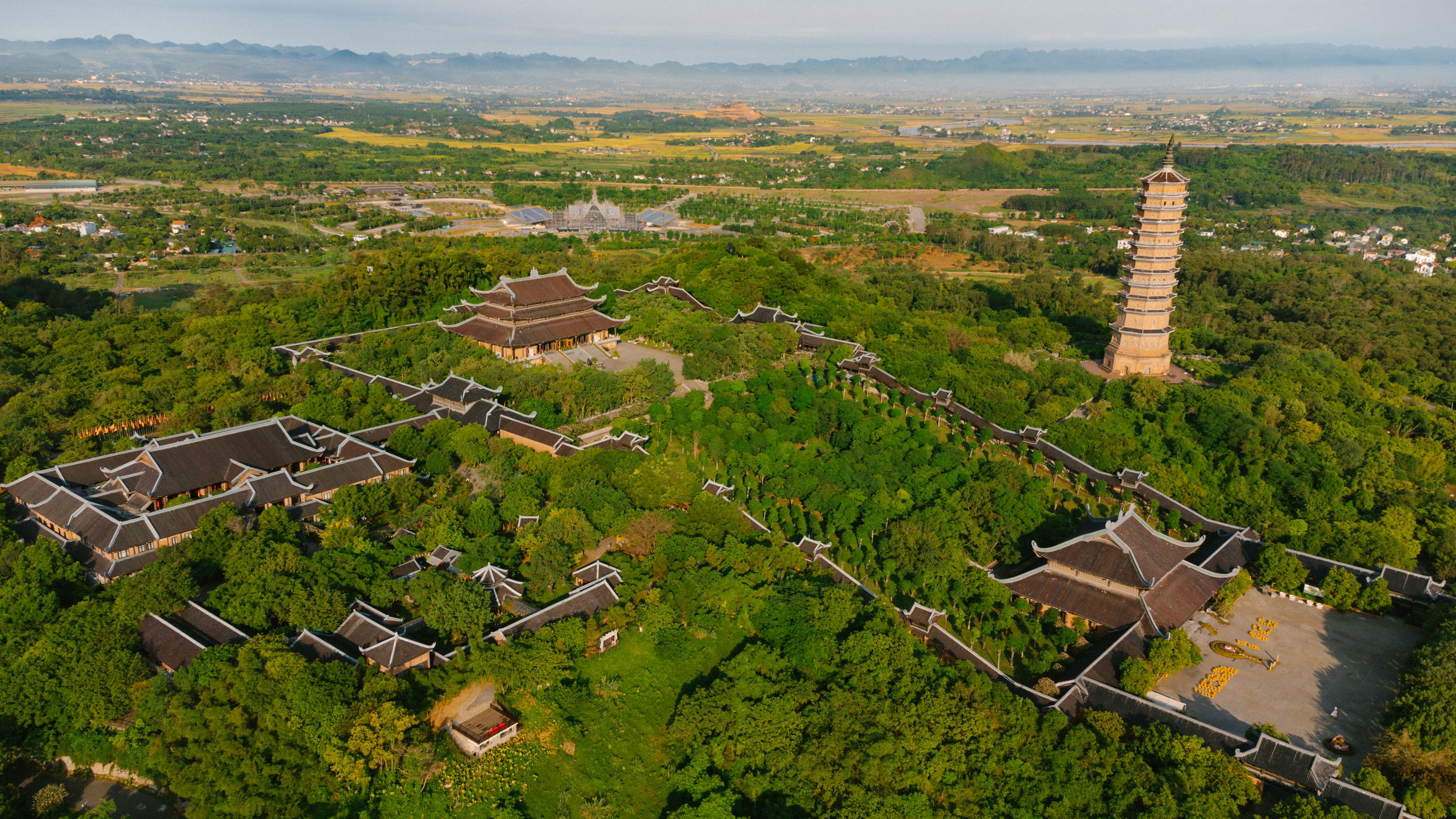 Stunning aerial view of Bai Dinh Pagoda amidst lush greenery in Ninh Bình, Vietnam.