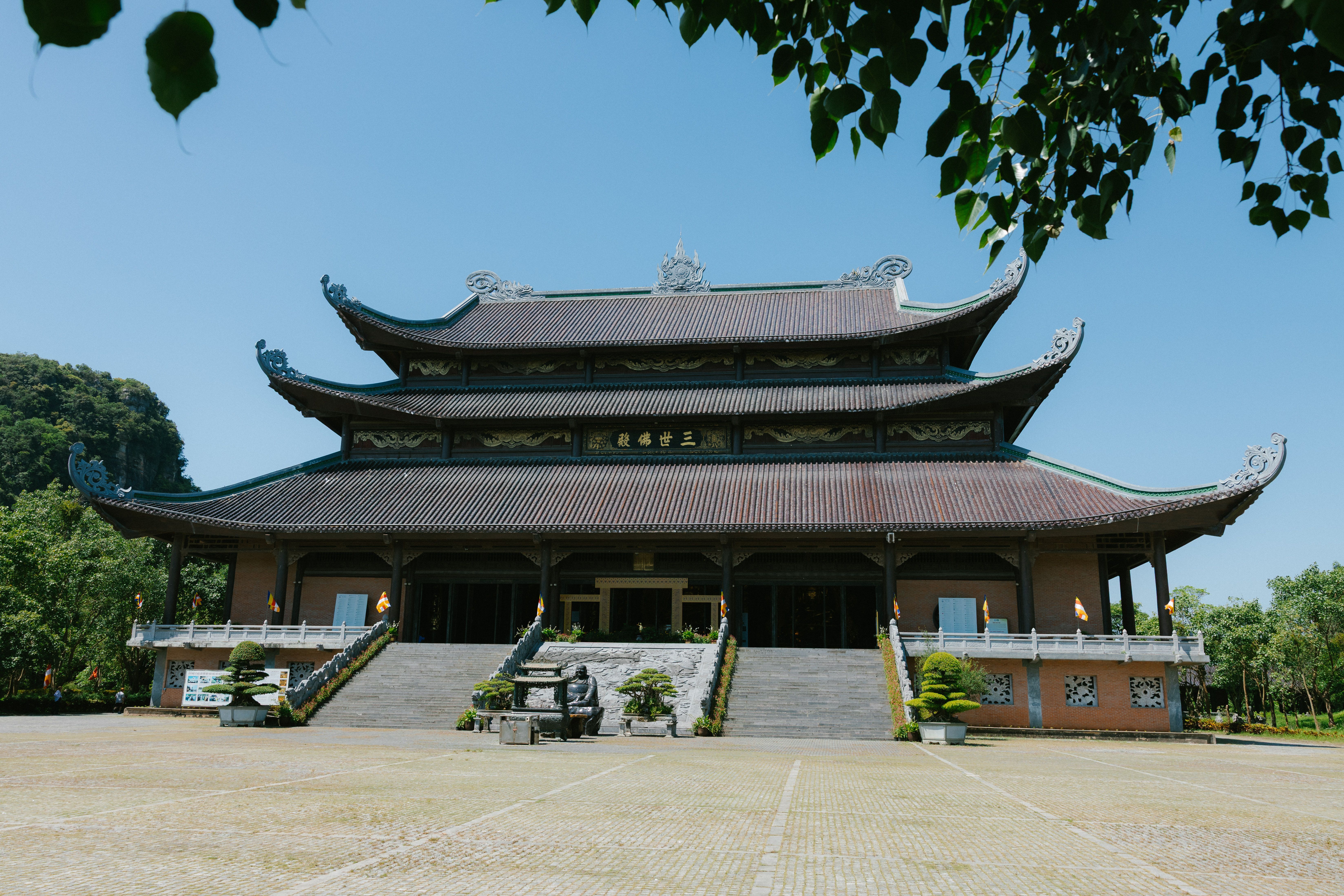 Front view of the majestic Bai Dinh Pagoda under a clear blue sky in Ninh Binh, Vietnam.