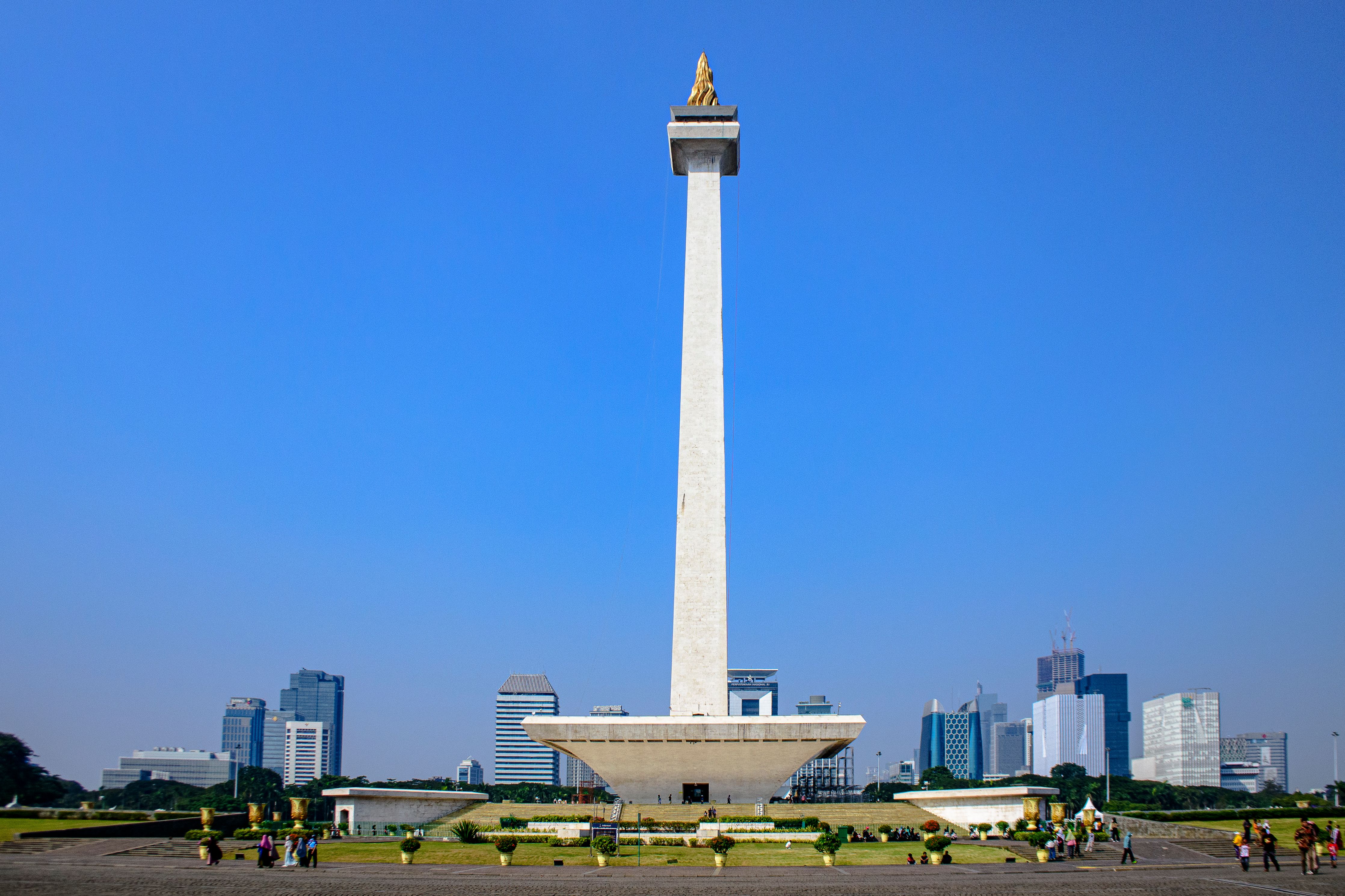 The iconic National Monument (Monas) standing tall against the Jakarta skyline on a clear day.