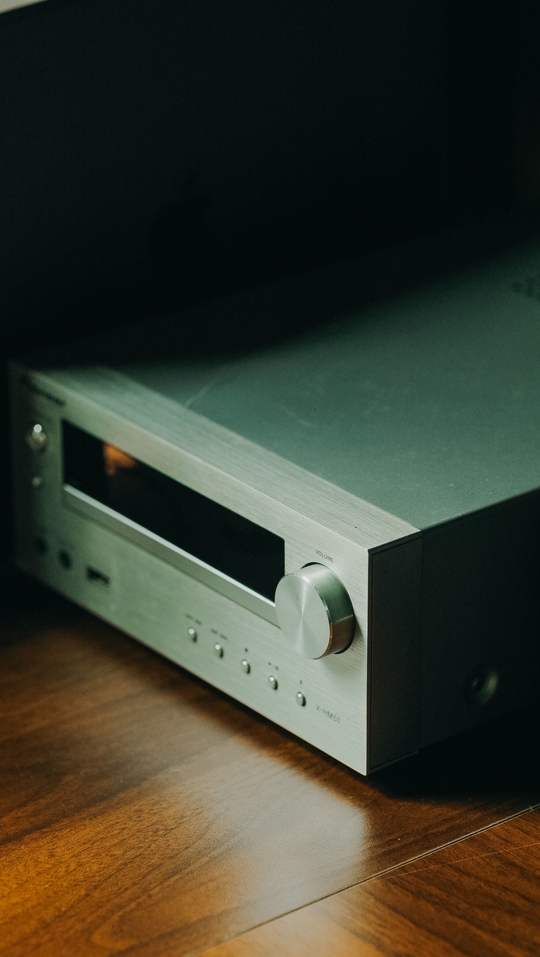Close-up of a modern silver stereo receiver on a wooden floor, offering audio elegance.