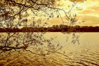 秋叶映衬着宁静的河景，倒映在平静的水面上