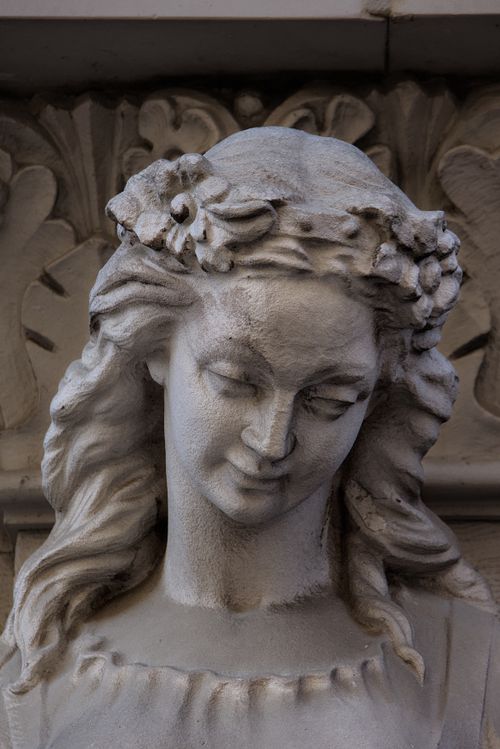 Free Close-up of a detailed stone sculpture of a woman in Warsaw, showcasing classical European art. Stock Photo