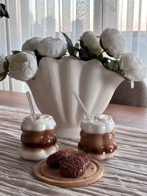 Free Glass cups of iced coffee with a white flower vase in the background. Stock Photo