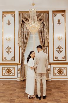 A sophisticated portrait of a couple embracing in an opulent wedding venue in Istanbul.