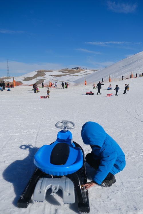 Free Children enjoying sled rides on a sunny winter day in Isparta, Türkiye. Stock Photo