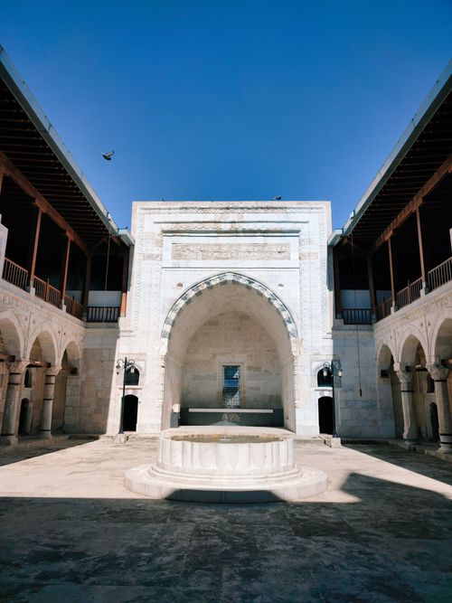 Free Majestic stone courtyard with central fountain under clear blue sky in Sivas, Türkiye. Stock Photo