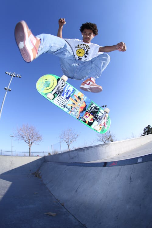Free Cool black teenager doing skateboard trick Stock Photo