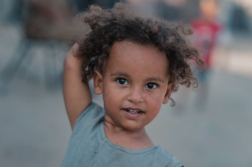 Free A smiling child with curly hair enjoying outdoor playtime, close-up. Stock Photo