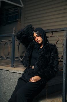 Fashionable woman in black fur coat posing with elegance in Alexandria.