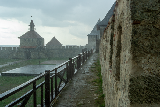 Moody capture of a historic fortress with rain falling on stone walls.