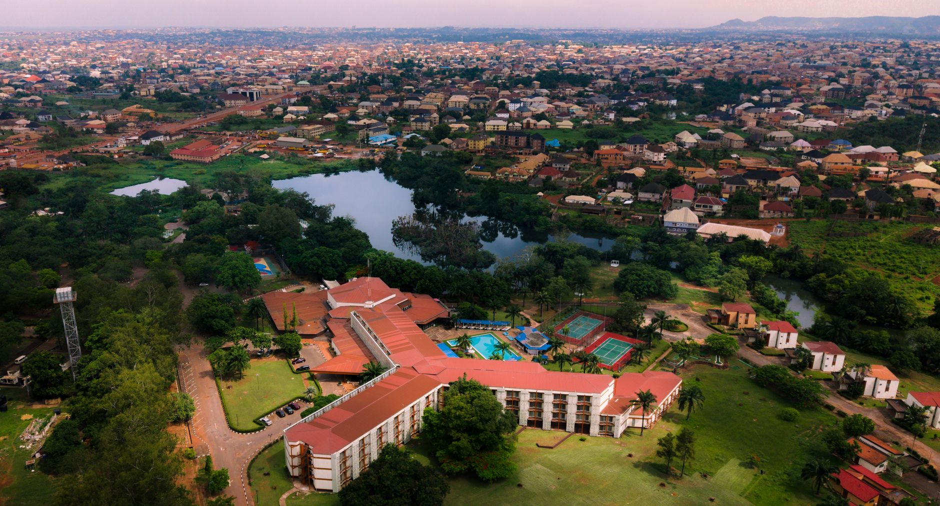 Aerial view of Enugu, Nigeria showcasing urban landscape, lush greenery, and residential structures.